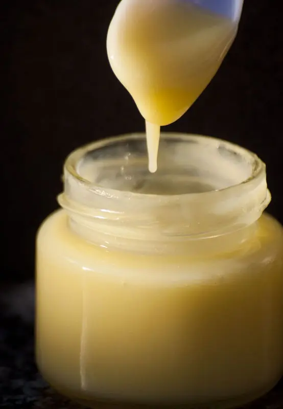 Gelee Roylae wird mit einem Löffel aus einem Glas gehoben